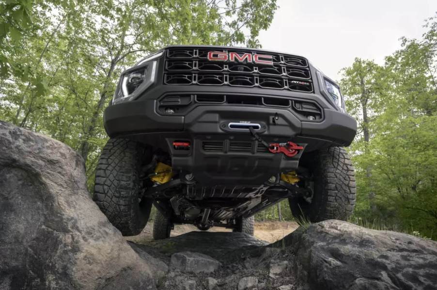 The 2023 GMC Canyon AT4X AEV climbing over rocks