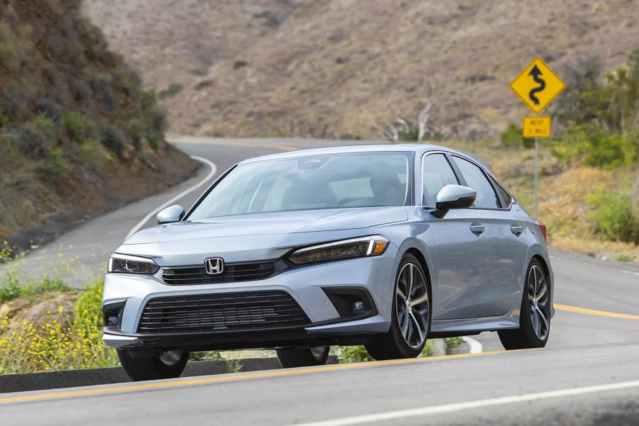 A gray 2023 Honda Civic Touring sedan on an open road.