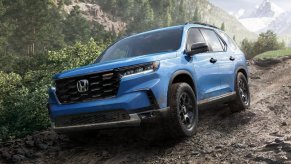 2023 Honda Pilot midsize SUV driving on dirt road