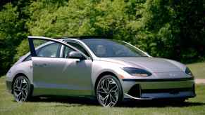 A silver 2023 Hyundai Ioniq 6 sits in front of green trees.