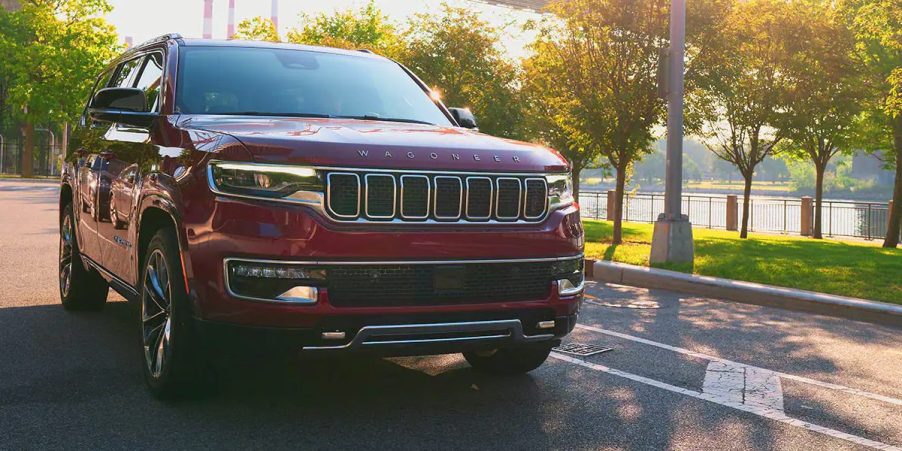 A red 2023 Jeep Wagoneer full-size SUV is driving on the road.