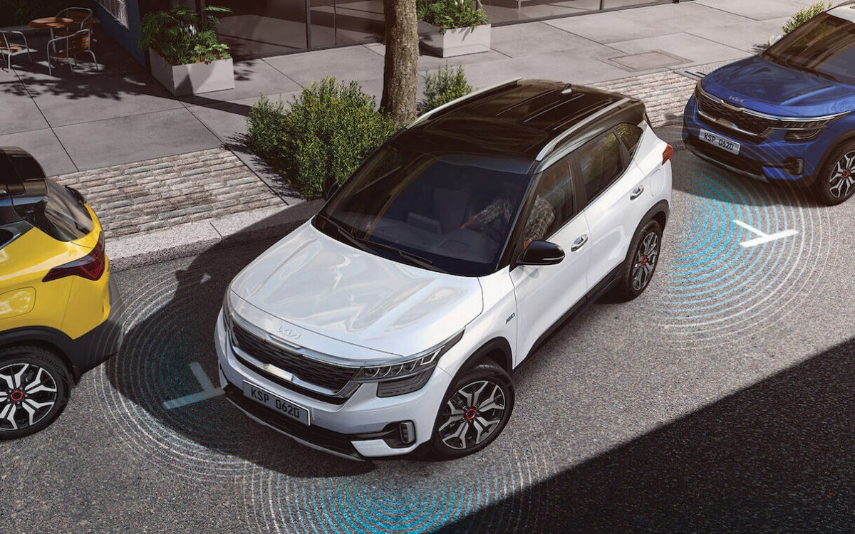 The 2023 Kia Seltos in white using parking sensors to parallel park.