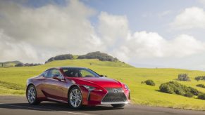 A red 2023 Lexus LC 500 parked near a green field