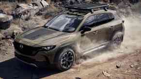 The 2023 Mazda CX-50 Meridian SUV drives on an off-road trail.