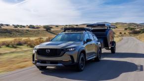 The 2023 Mazda CX-50 Meridian Edition tows a small camper trailer.