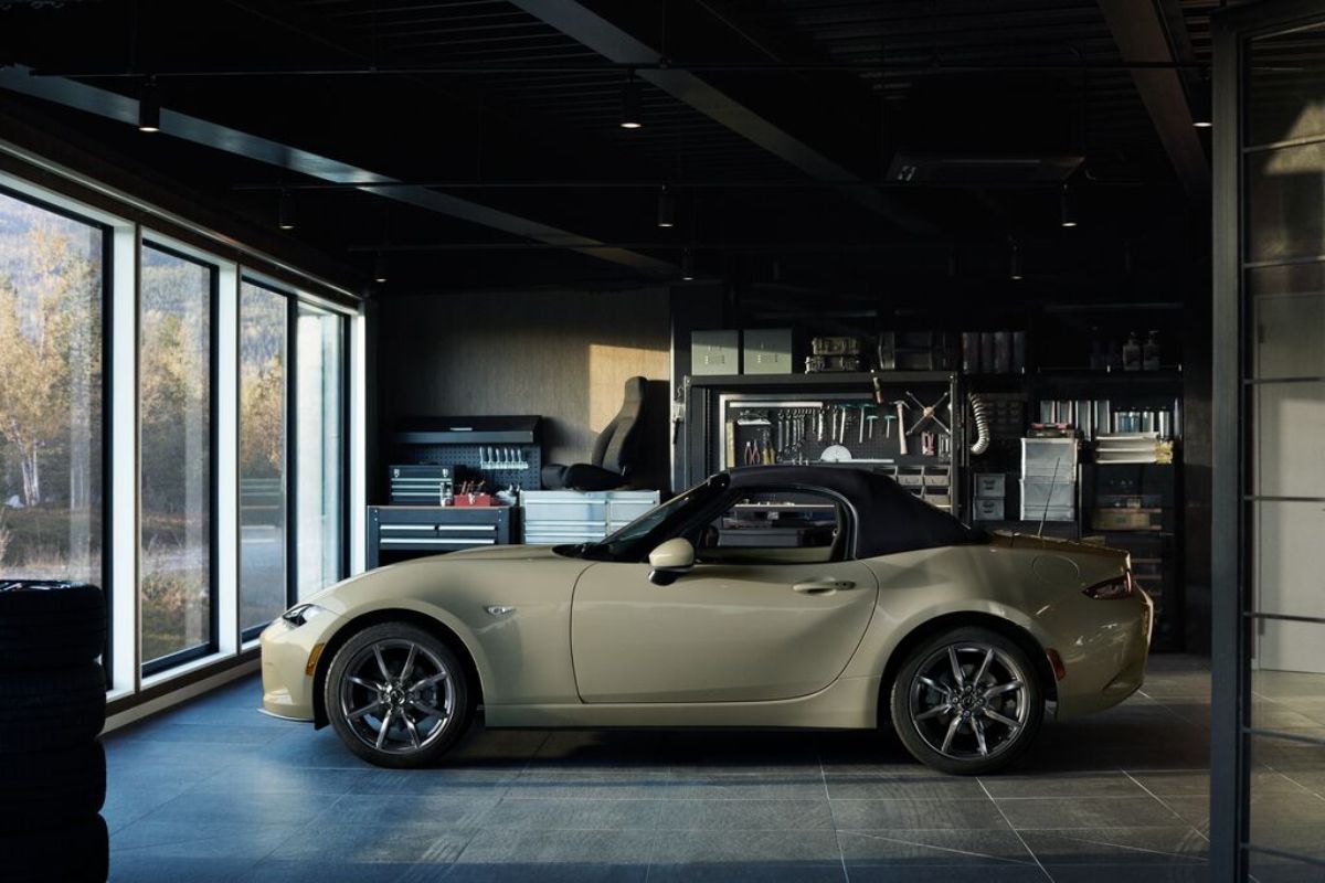 A tan 2023 Mazda MX-5 Miata in a garage.