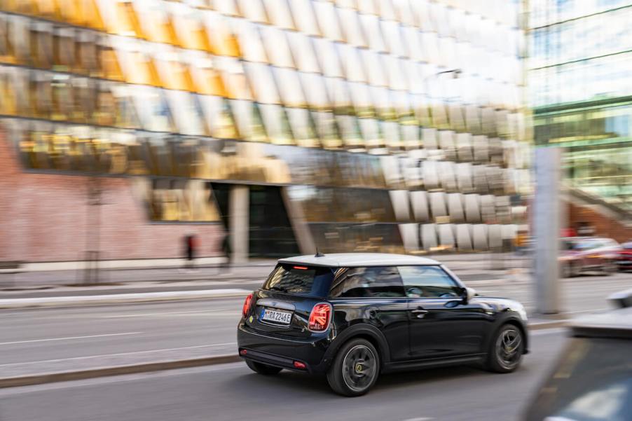 A black 2023 Mini Cooper S driving through downtown streets