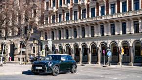 A black 2023 Mini Cooper parked in a small town in Italy