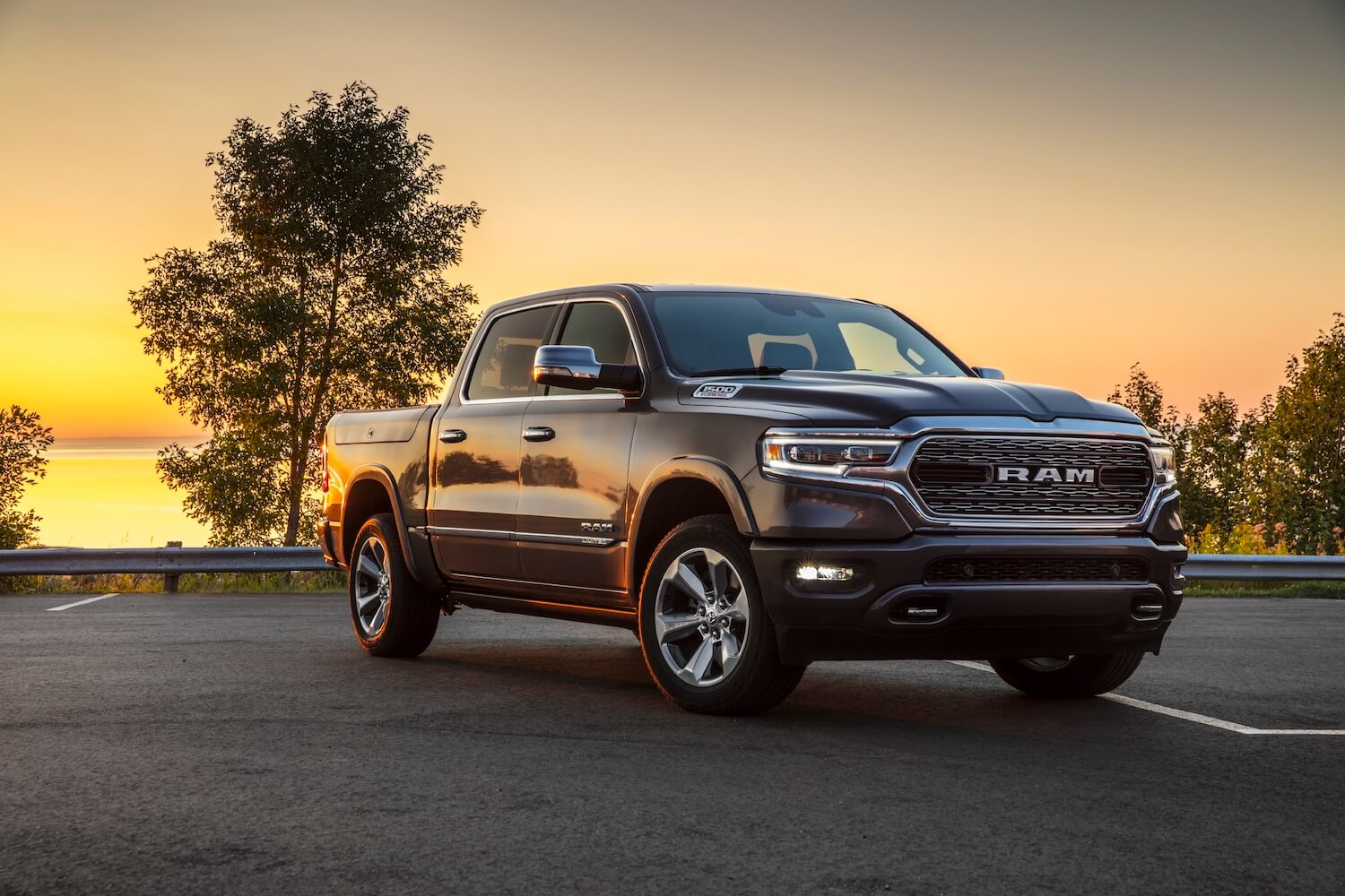 Gray Ram 1500 pickup truck with air suspension parked in front of a sunset.