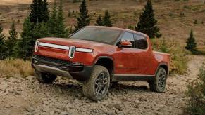 The 2023 Rivian R1T off-roading over rocky terrain