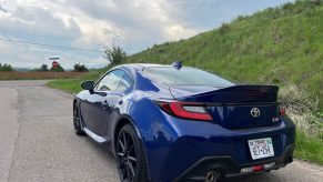 A rear view of the 2023 Toyota GR86 near a hill