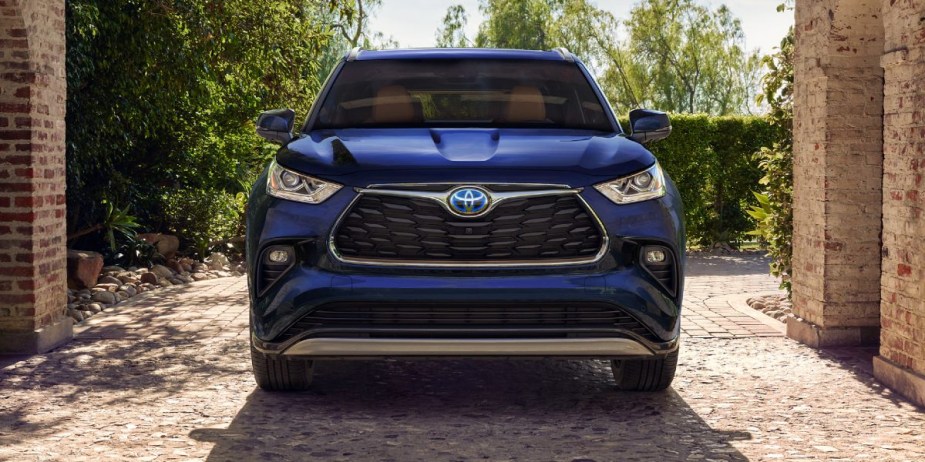 A blue 2023 Toyota Highlander Hybrid midsize hybrid SUV is parked. 