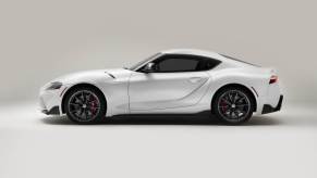 A white 2023 Toyota Supra parked in a studio