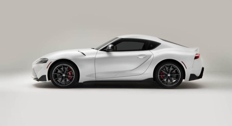 A white 2023 Toyota Supra parked in a studio