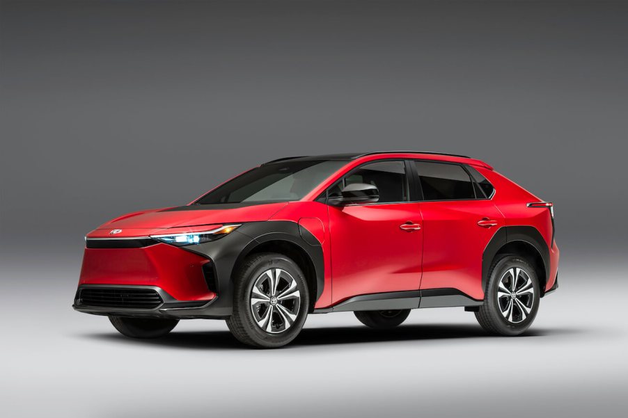 A red 2023 Toyota bZ4X XLE in front of a gray background.