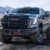 The 2024 GMC Sierra 2500HD AT4X AEV Edition off-roading over rocks