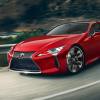 A red 2024 Lexus LC driving around a bend