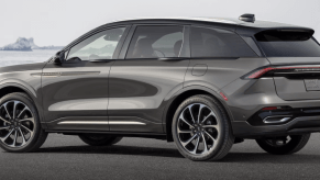 A side profile shot of a 2024 Lincoln Nautilus Hybrid Black Label midsize luxury SUV model parked by calm water