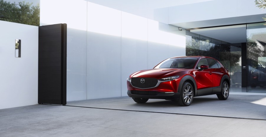 A red 2023 Mazda CX-30 sits in front of a white wall. It's a fun compact SUV.