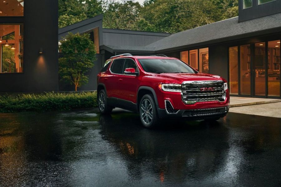 A red GMC Acadia in the rain. The GMC Acadia has three common problems that owners report. Is it reliable?