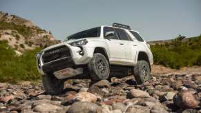 A white Toyota 4Runner TRD Pro traverses across a rocky wash. The 4Runner is one of the most reliable Toyota SUVs.