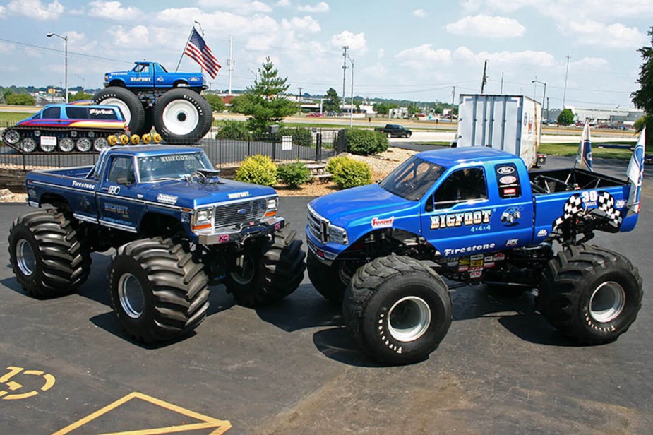 Four different versions of the Ford F-250 Bigfoot monster truck in a parking lot for a publicity photo.