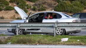 girl looking out the window of a broken down car