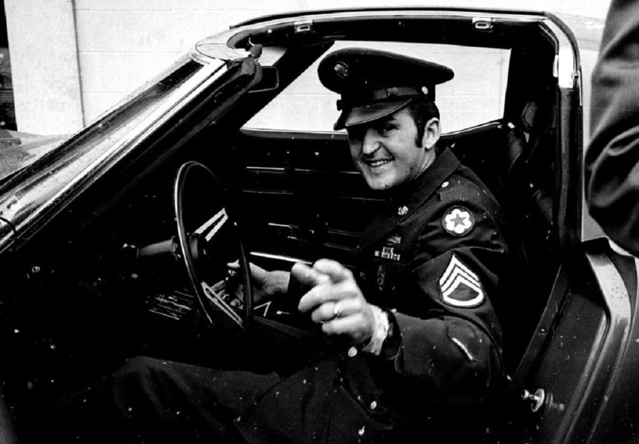 A U.S. Army Staff Sergeant inspects the T-tops on a C3 Corvette.