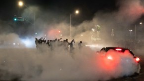 Car sideshow with car doing donuts on public road