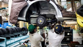 Two men working a car's axle