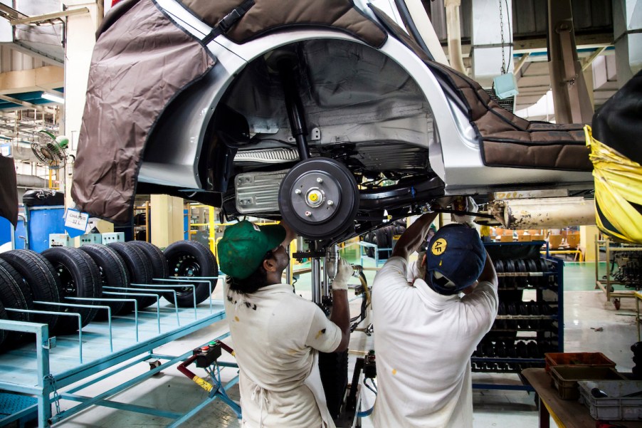 Two men working a car's axle