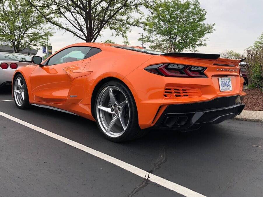 A bright orange hybrid electric Chevrolet Corvette E-Ray C8 shows off its rear-end styling.