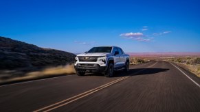 The 2024 Chevy Silverado 1500 EV is driving down the road as an electric truck.