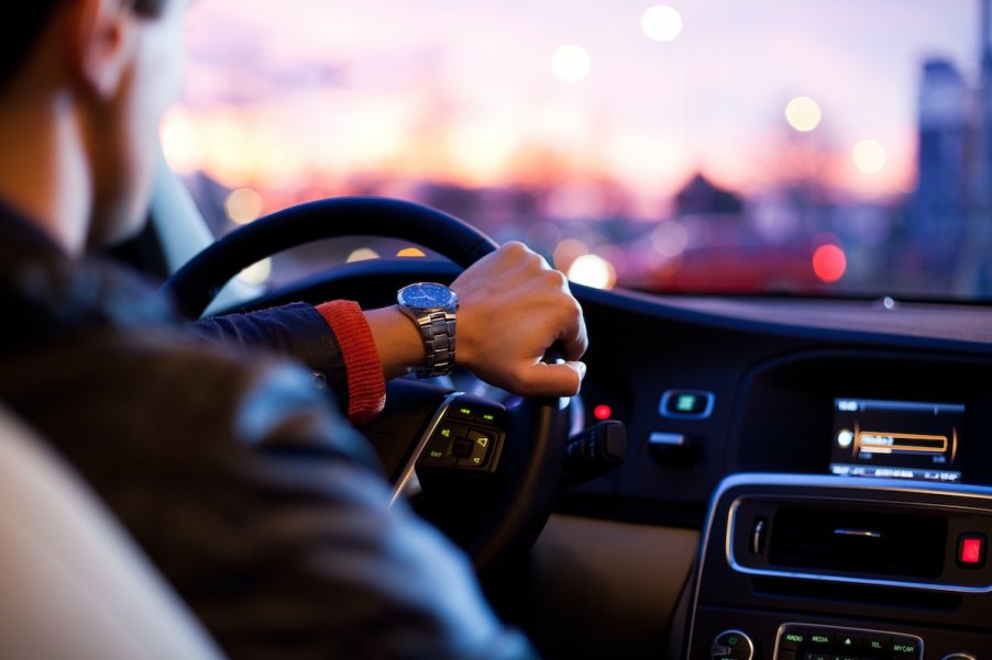 A man driving a car, which may or may not have a car immobilizer system standard