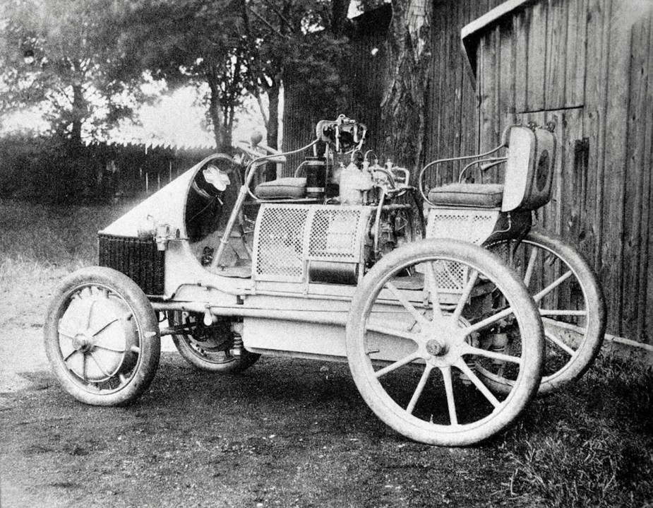 A porsche Semper Vivus electric vehicle parked in front of a barn.