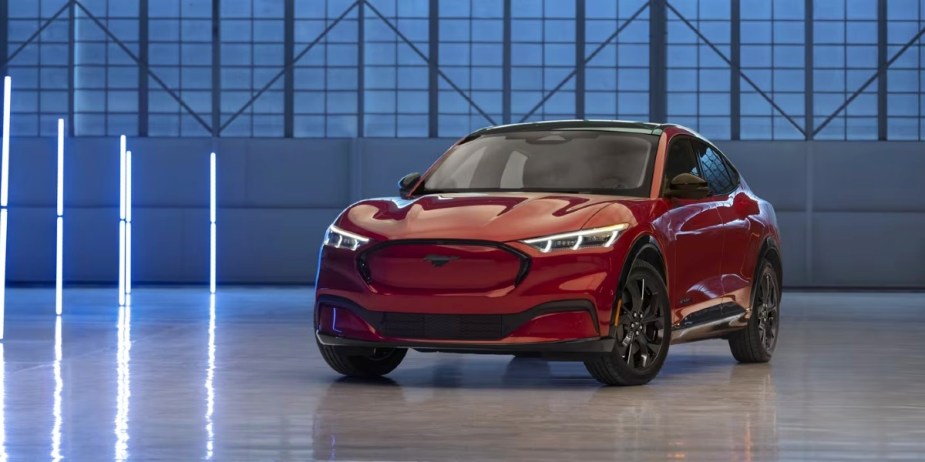 A red 2023 Ford Mustang Mach-E small electric SUV is parked. 