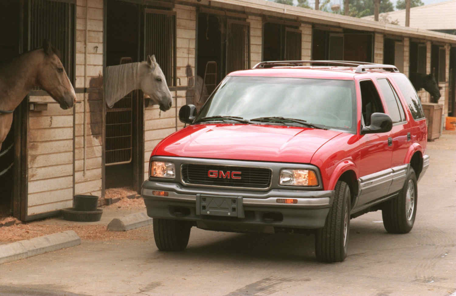 A 1995 GMC Jimmy SUV and some horses