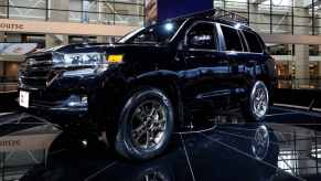 Long known as one of the best three-row off-road SUVs, the Toyota Land Cruiser sits on display at an auto show.