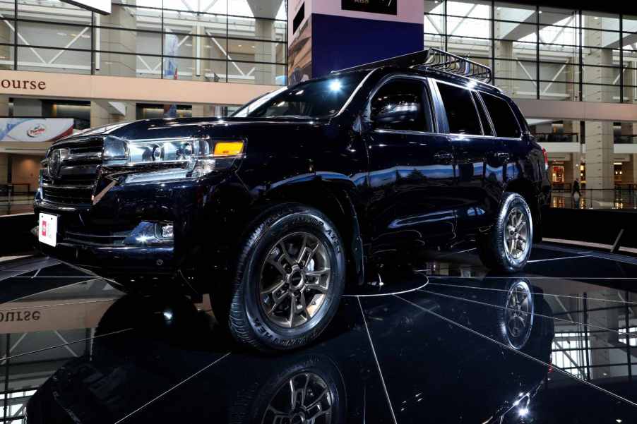 Long known as one of the best three-row off-road SUVs, the Toyota Land Cruiser sits on display at an auto show.