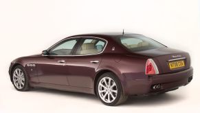 A maroon Maserati Quattroporte parked in a studio