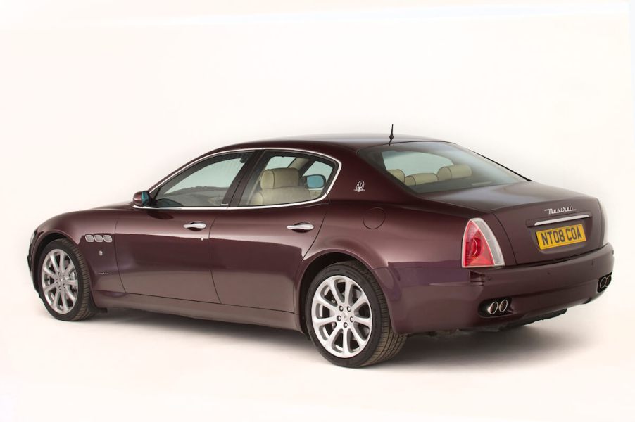 A maroon Maserati Quattroporte parked in a studio