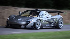 A silver McLaren P1 HDK racecar driving on a country road