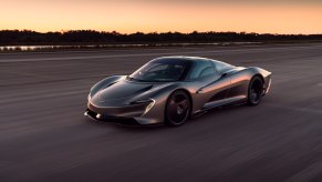 A black 2020 McLaren Speedtail driving down a runway during a sunset