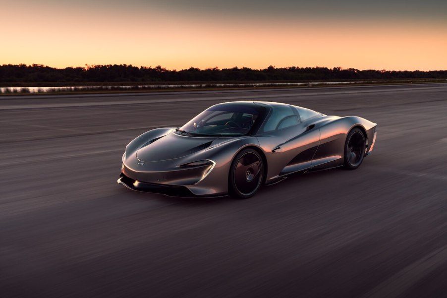 A black 2020 McLaren Speedtail driving down a runway during a sunset