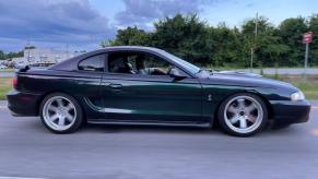 A Mystichrome Ford Mustang Cobra driving down the road