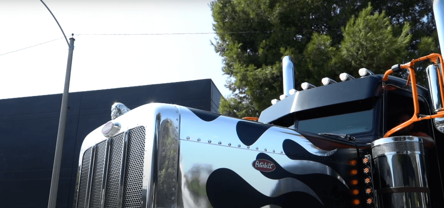 The chrome hood decals and hood ornament of on a custom Peterbilt truck.