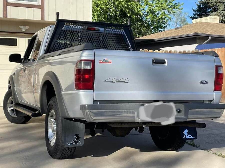 A Ford pickup truck with the silhouette of a girl visible on its mudflaps.