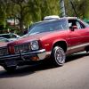 A Pontiac Le Mans driving in a parking lot.