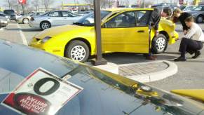 GMC General Sales Manager David Lyon shows prospective buyers a new Pontiac Sunfire in December 2001