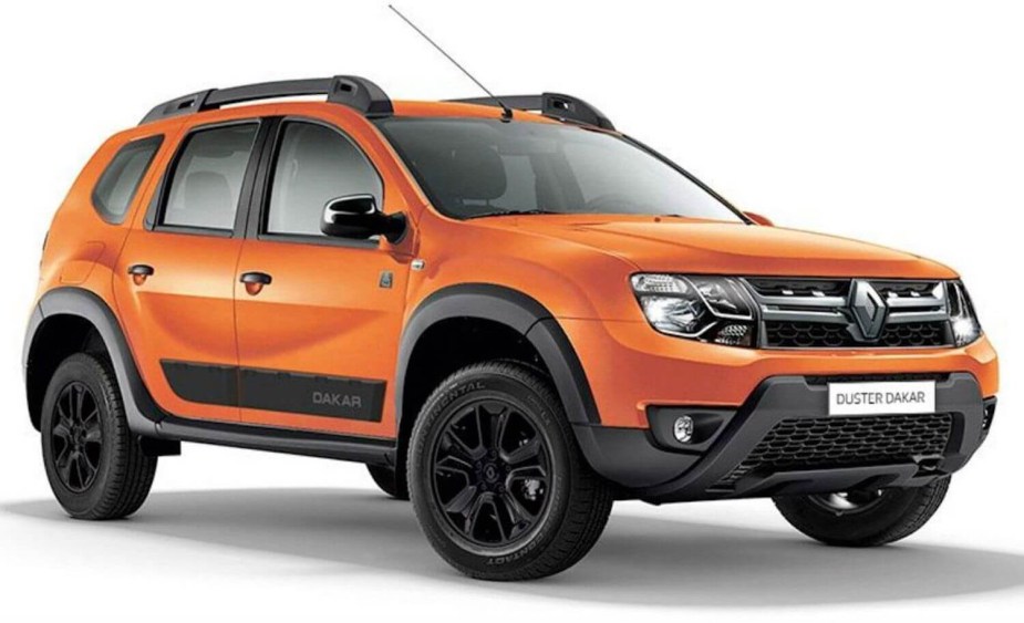 An orange Renault Duster Dakar off-road crossover SUV against a white backdrop.